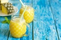 Fresh pineapple smoothie in two glasses on a blue wooden rustic background Royalty Free Stock Photo