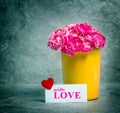 Fresh pink carnation flower and love card over stone plate background Royalty Free Stock Photo