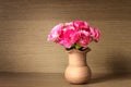 The Fresh pink carnation flower on wooden shelf background