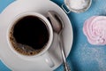 Fresh pink homemade zephyr - marshmallow and white cup of tea on blue wooden table Royalty Free Stock Photo