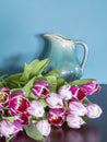 Fresh pink and red tulip flowers bouquet on shelf in front of green wall. View with copy space Royalty Free Stock Photo