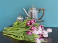 Fresh pink and red tulip flowers bouquet on shelf in front of green wall. View with copy space Royalty Free Stock Photo