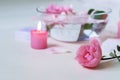 Fresh pink roses, water, petals, candles on a light background