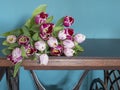 Fresh pink tulip flowers bouquet on a old brown table in front of a green wall. View with copy space and shadow Royalty Free Stock Photo