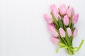 Fresh pink tulip flowers bouquet on shelf in front of wooden wall. Royalty Free Stock Photo