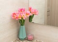 fresh pink tulips in vase and candle on bathroom countertop Royalty Free Stock Photo