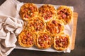 Fresh pizza pot pies with tomatoes, cheese and sausages on a wooden board top view Royalty Free Stock Photo