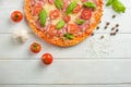 Fresh pizza with tomatoes, cheese and salami on a wooden table close-up Royalty Free Stock Photo