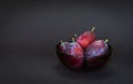 Fresh plum. Autumn harvest. Ripe purple plums in glass bowl on dark background. Concept: seasonal fruits, healthy food. Close up. Royalty Free Stock Photo