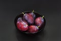 Fresh plum. Autumn harvest. Ripe purple plums in glass bowl on dark background. Concept: seasonal fruits, healthy food. Top view. Royalty Free Stock Photo