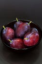 Fresh plum. Autumn harvest. Ripe purple plums in glass bowl on dark background. Concept: seasonal fruits, healthy food. Top view. Royalty Free Stock Photo