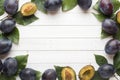 Fresh plum fruit with leaves on a light table. Royalty Free Stock Photo