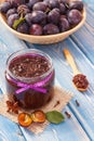 Fresh plum marmalade or jam in jar, spices and ripe fruits in wicker basket, healthy sweet dessert Royalty Free Stock Photo