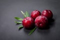 Fresh plums on black wooden table