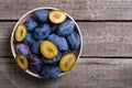 Fresh plums in bowl on wooden table Fruit background Royalty Free Stock Photo