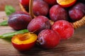 Fresh plums falling out of a basket Royalty Free Stock Photo