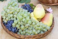 Fresh plums, grapes and pears in wooden basket