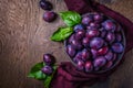 Fresh plums on plate over dark wooden background Royalty Free Stock Photo