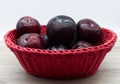 Fresh plums in a red basket isolated on white background Royalty Free Stock Photo
