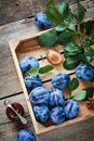 Fresh plums in wooden box and jar of fruit jam. Top view.