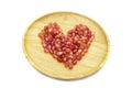 Fresh pomegranate heart shape on wooden plate isolated