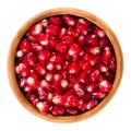 Fresh pomegranate seeds in wooden bowl over white Royalty Free Stock Photo