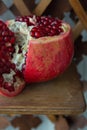 Juicy pomegranate fruit on a wooden suport.