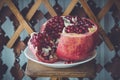 Juicy pomegranate fruit on a wooden suport.