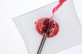 Fresh pomegrate being cut in half with a knife