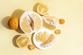 Fresh pomelo half, wedges, pulp, rind, oranges and tangerines on a yellow background