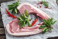 Fresh Pork middle cut ready to cook served with sage, red onion, chillies and red pepper drizzled with olive oil on