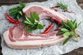 Fresh Pork middle cut ready to cook served with sage, red onion, chillies and red pepper drizzled with olive oil on