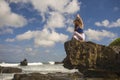 Oung attractive and concentrated woman practicing yoga meditation exercise smiling happy and relaxed at beautiful beach rock cliff