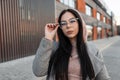 Fresh portrait young beautiful brunette woman with long hair with sexy lips in fashionable pink hooded sweatshirt in vintage coat Royalty Free Stock Photo