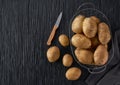 Fresh potato tubers on a black wooden table, top view Royalty Free Stock Photo
