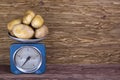 fresh potatoes on vintage scale and wood background Royalty Free Stock Photo