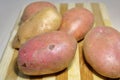 Fresh potatoes on a wooden board.