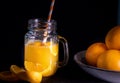 A glass with fresh orange juice with oranges in a bowl Royalty Free Stock Photo