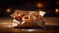 fresh pretzels with sea salt in a paper bag on top an old wooden table Royalty Free Stock Photo