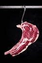 Fresh prime tomahawk beef steak hanging on a hook