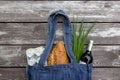 Fresh produce in blue denim market bag on wooden background, flat lay. Eco friendly reusable shopping bag for minimize waste,