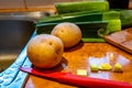 Fresh produce and red knife on a polished wood kitchen bench