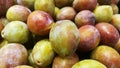 Close-up of a fresh prune. A pile of fresh prunes is displayed in the fruit section of the supermarket.