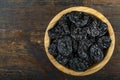 Fresh prunes in wooden bowl. Dried plums