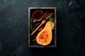 Fresh pumpkin with honey, healthy food. On a black stone background.