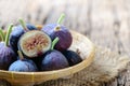 Fresh purple fig fruit and slices isolated in bamboo basket on old wood background Royalty Free Stock Photo