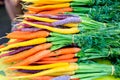 Fresh purple and orange carrots on display at the farmers market.