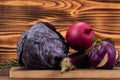 Fresh purple vegetables like onion, daikon radish, cabbage and eggplant on a cutting board, wooden background Royalty Free Stock Photo