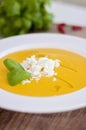 Fresh pureed sweet potato soup with cheese and basil leaves as garnish. Pureed vegetable soup on a white plate or bowl, on a Royalty Free Stock Photo