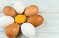 Fresh quail and chicken eggs, egg yolk on white wooden background Royalty Free Stock Photo